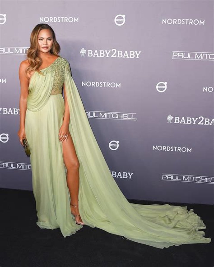 Chrissy Teigen Reveals She Still Has A ‘Bump’ While Rocking Cutout Dress 2 Mos. After Losing Baby